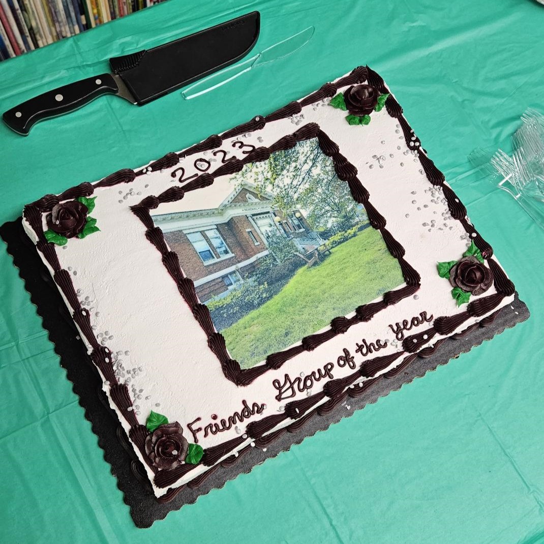 A large rectangular cake frosted with an edible image of the library.